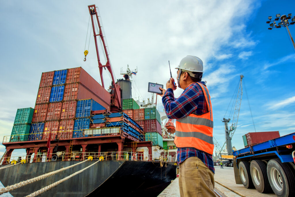 Port employee directing the movement of a container crane at a shipping terminal